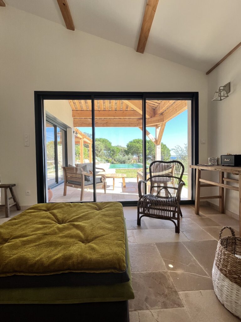 Séjour ouvert sur terrasse. Piscine à débordement, jardin et vue mer.